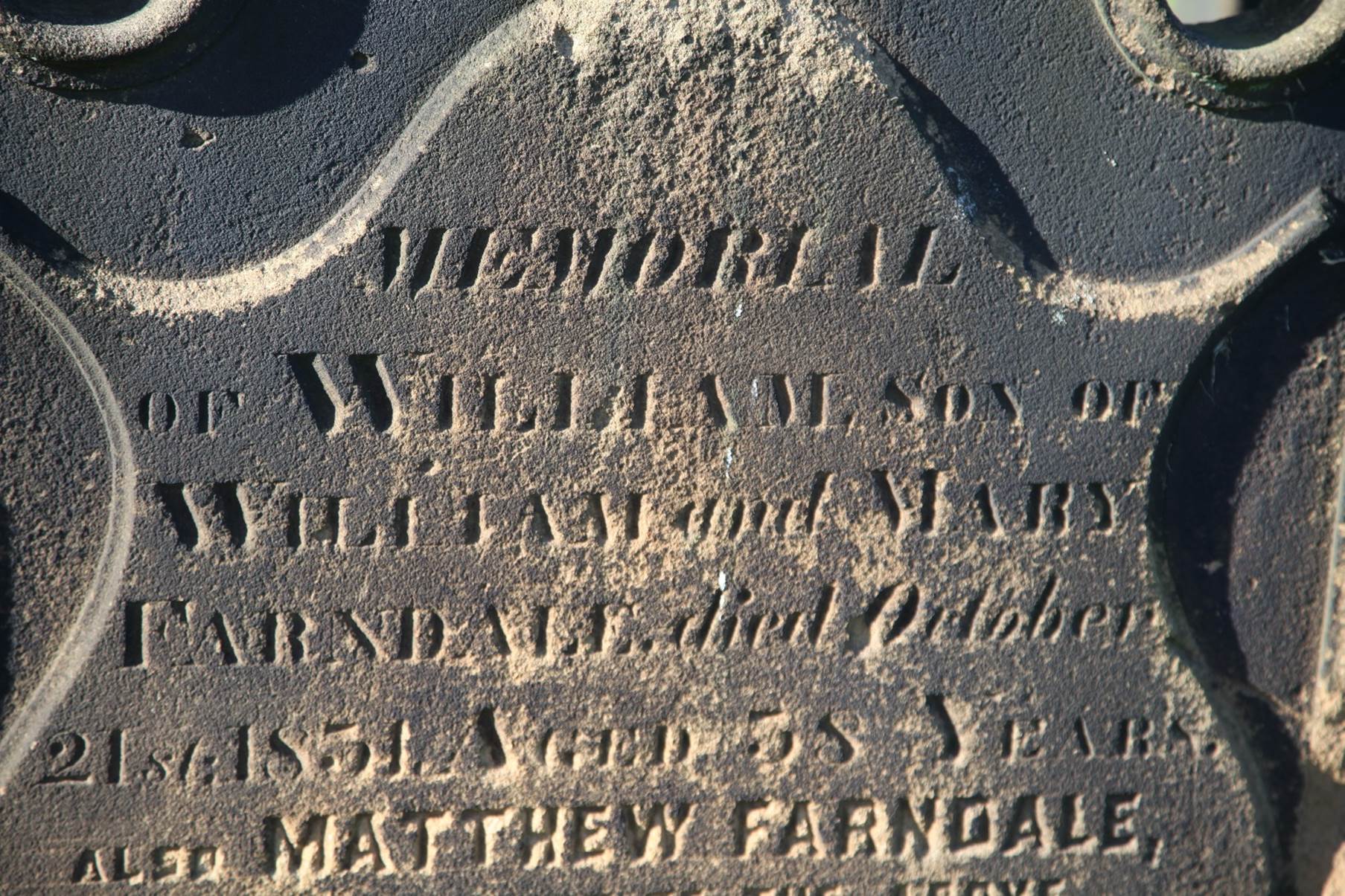 A close-up of a grave stone
Description automatically generated